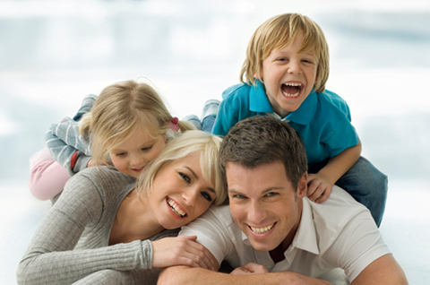 Family laying on the ground together smiling